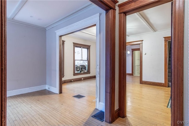 corridor with light hardwood / wood-style flooring and ornamental molding