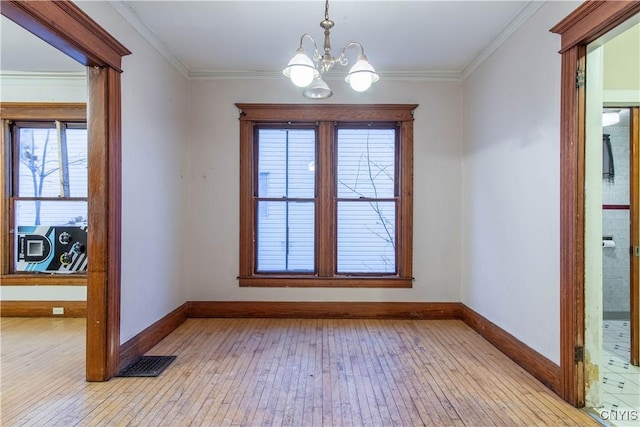 unfurnished dining area with crown molding, light hardwood / wood-style floors, and a notable chandelier