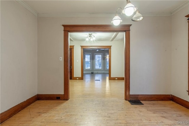 interior space featuring an inviting chandelier, crown molding, and light hardwood / wood-style flooring