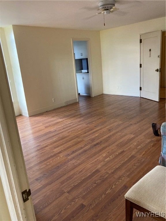 unfurnished living room with ceiling fan and dark hardwood / wood-style flooring