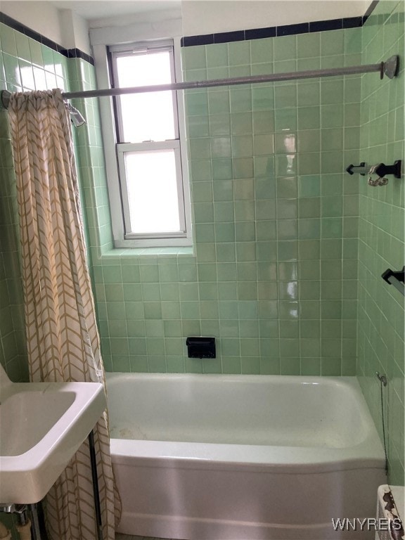 bathroom with shower / bath combination with curtain and sink