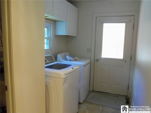 laundry room featuring cabinets, a healthy amount of sunlight, and washing machine and dryer