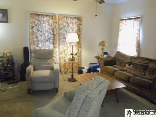 carpeted living room with ceiling fan