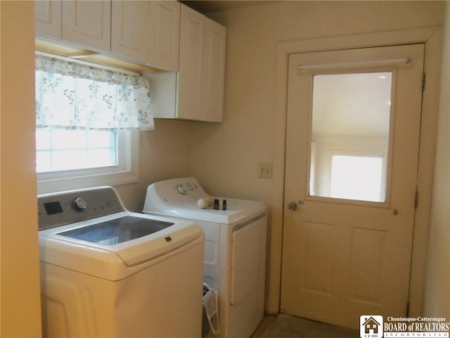 clothes washing area featuring cabinets and washer and dryer