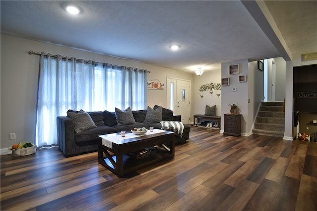 living room with a textured ceiling and dark hardwood / wood-style floors