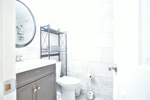 bathroom with tile walls, vanity, and toilet