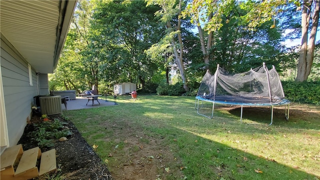 view of yard with a trampoline, a storage shed, and a patio area