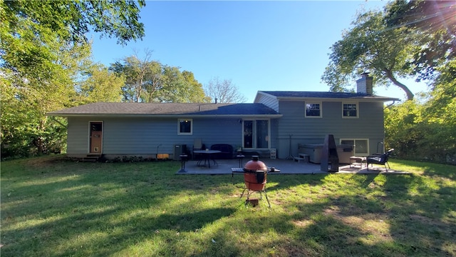 rear view of property featuring a lawn and a patio