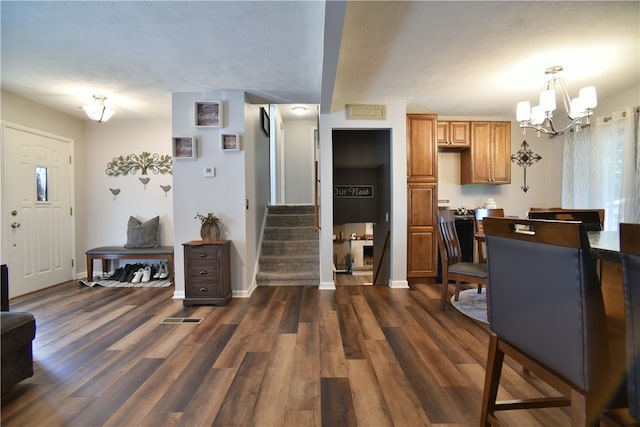 interior space featuring an inviting chandelier, hanging light fixtures, dark hardwood / wood-style flooring, and a textured ceiling