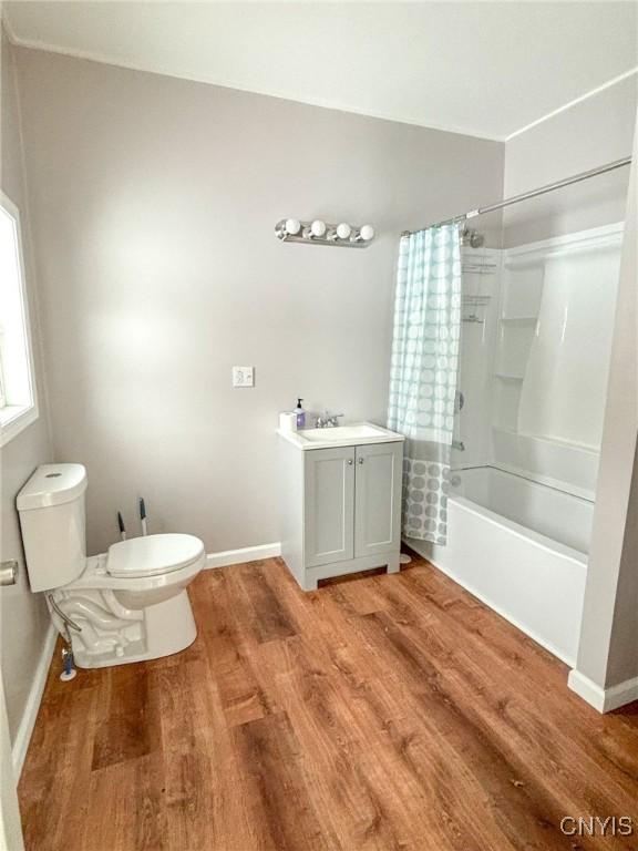 full bathroom featuring hardwood / wood-style floors, shower / bath combination with curtain, toilet, and vanity