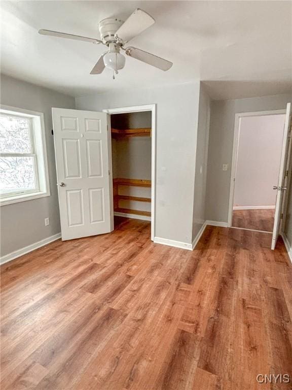 unfurnished bedroom with light hardwood / wood-style flooring, a closet, and ceiling fan