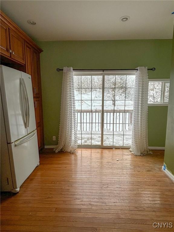 interior space featuring light hardwood / wood-style flooring and white fridge