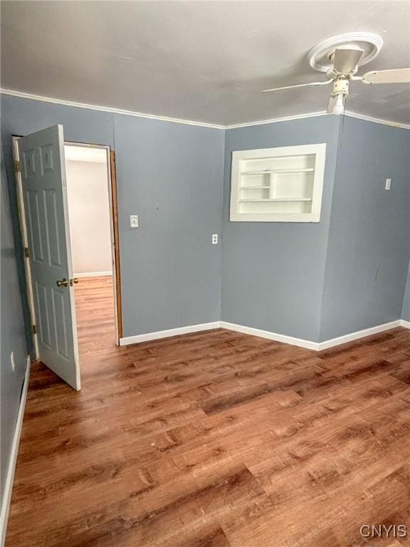 empty room with hardwood / wood-style floors, ceiling fan, and ornamental molding