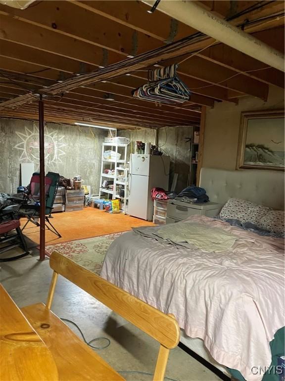 28541 Hewitt Dr, Lyme, NY 13622 - bedroom with freestanding refrigerator and concrete floors
