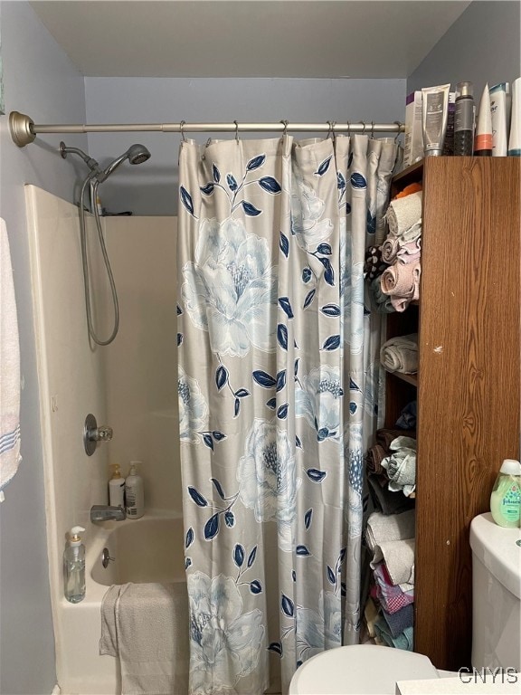 bathroom featuring shower / bath combo with shower curtain and toilet