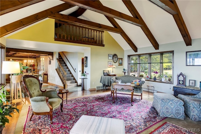 living room featuring beamed ceiling, an inviting chandelier, high vaulted ceiling, and baseboard heating