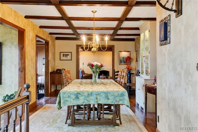 dining area with wood-type flooring, beam ceiling, coffered ceiling, and a notable chandelier