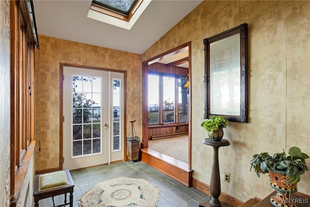 entryway featuring a baseboard radiator and lofted ceiling with skylight