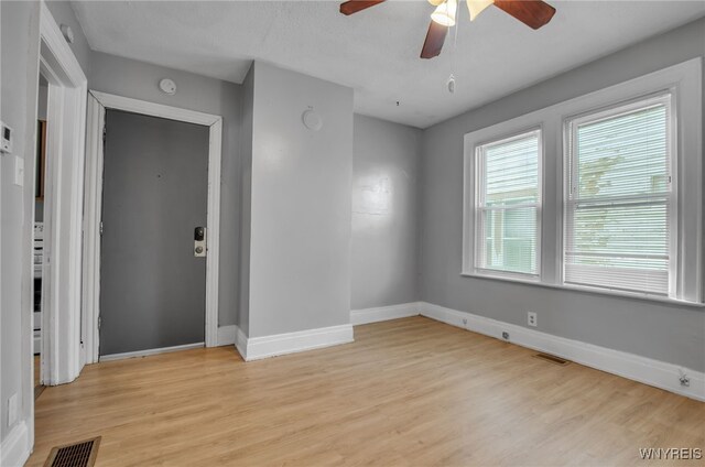 empty room featuring light wood-type flooring and ceiling fan