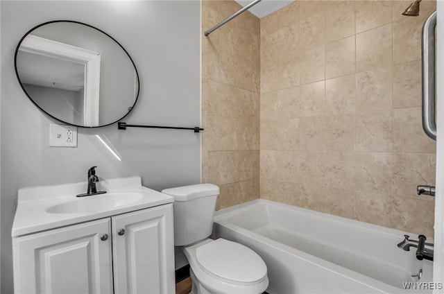 full bathroom with tiled shower / bath, vanity, and toilet