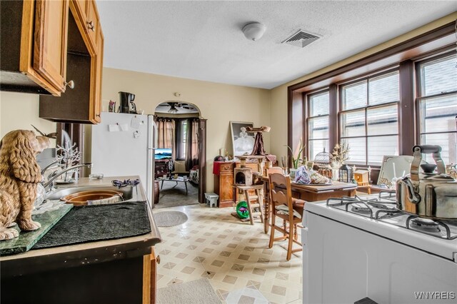 kitchen featuring white appliances, a textured ceiling, and sink