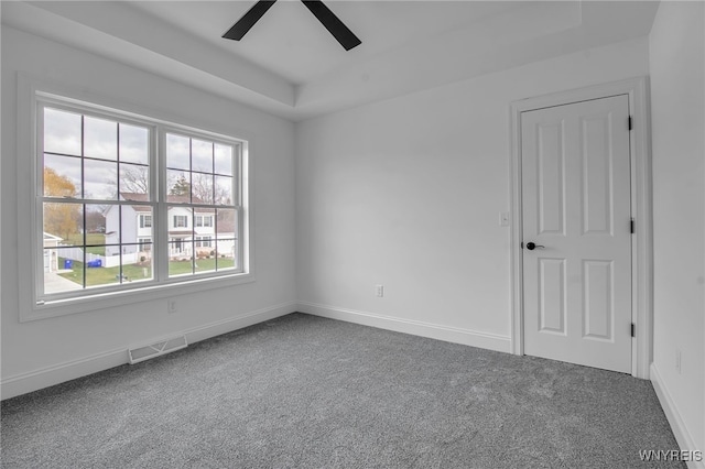 empty room featuring ceiling fan and carpet