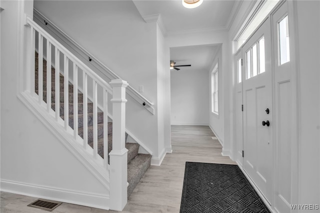 foyer entrance featuring ceiling fan, light hardwood / wood-style floors, and crown molding