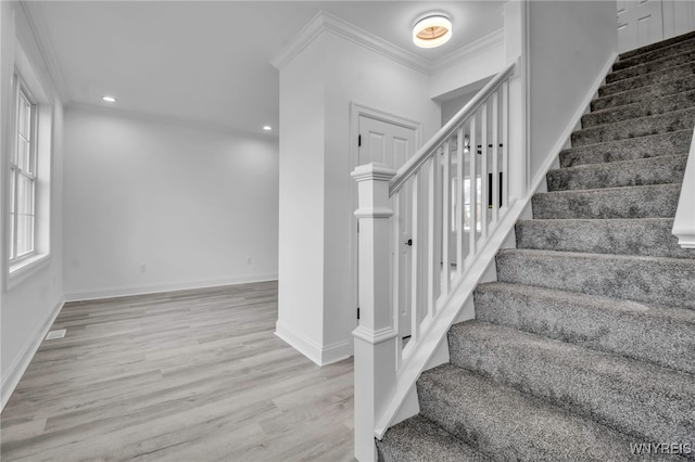 staircase with crown molding and hardwood / wood-style floors