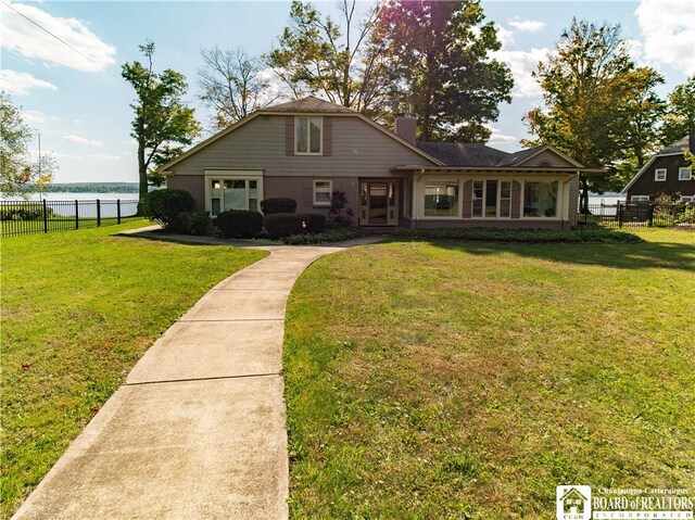 view of front of home with a water view, a front yard, and fence