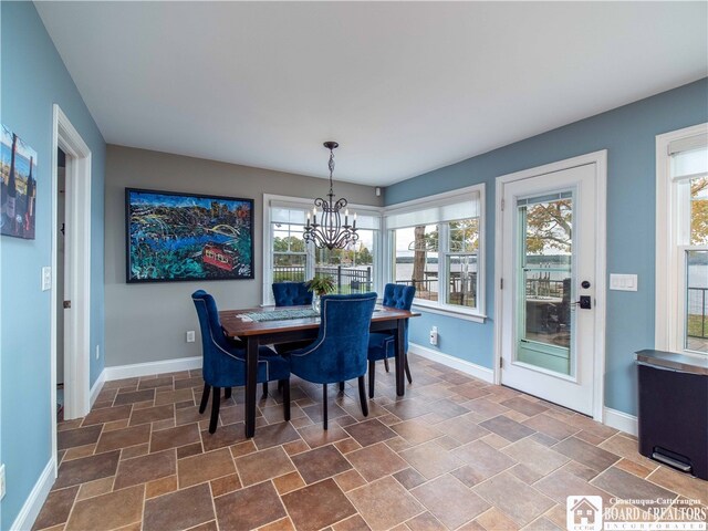 dining space with baseboards and an inviting chandelier