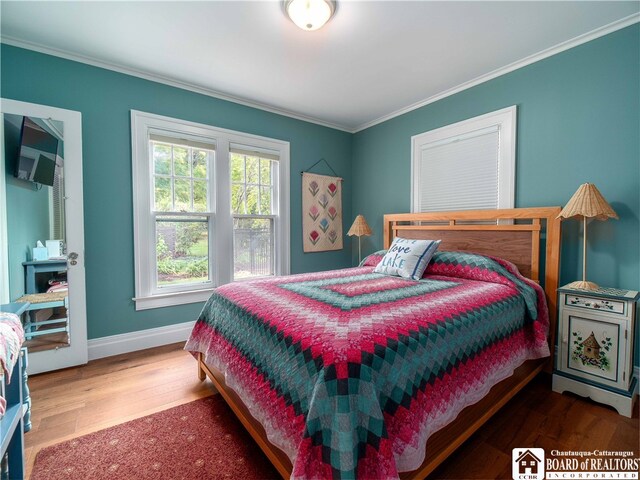 bedroom featuring crown molding, baseboards, and wood finished floors