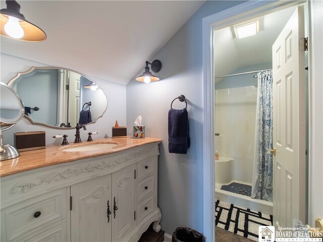 bathroom featuring lofted ceiling, a shower with curtain, and vanity