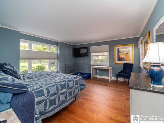 bedroom featuring multiple windows, wood finished floors, and crown molding