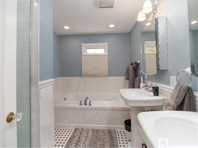 full bath with visible vents, a garden tub, a wainscoted wall, and tile patterned flooring