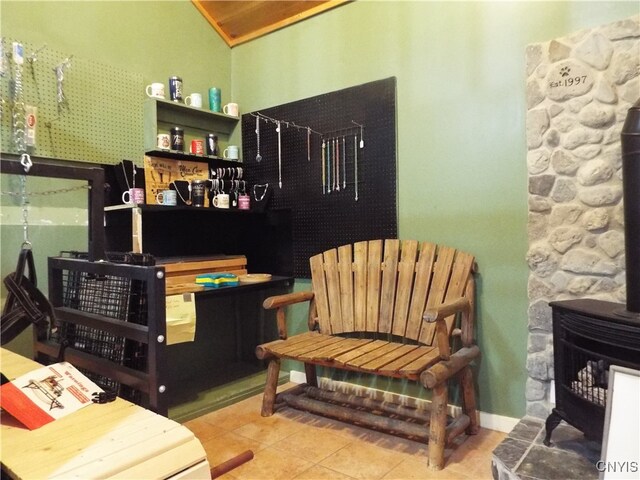 sitting room with tile patterned flooring and a wood stove