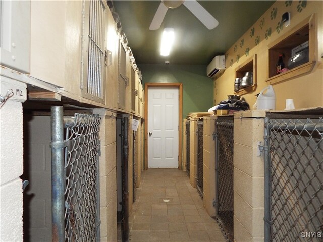 storage area with an AC wall unit and ceiling fan