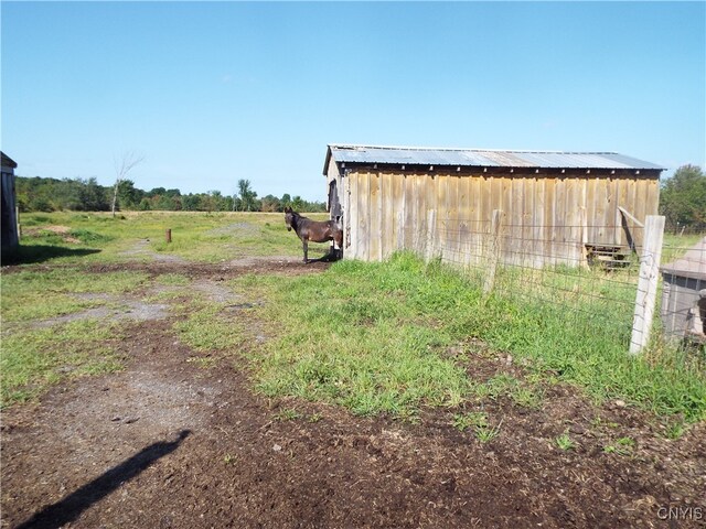 view of yard with an outdoor structure and a rural view