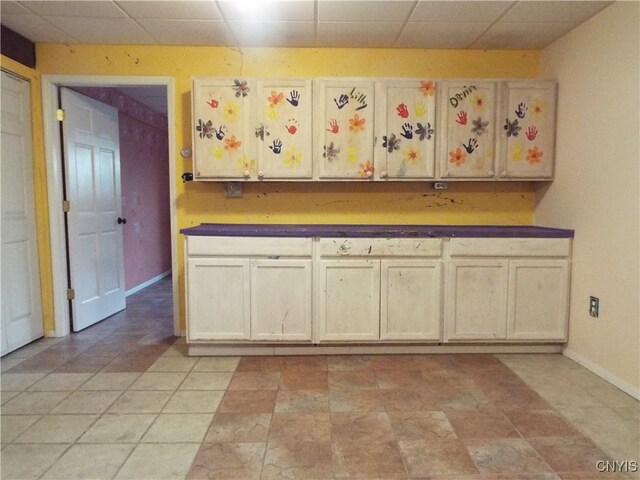 kitchen with a drop ceiling and light tile patterned floors