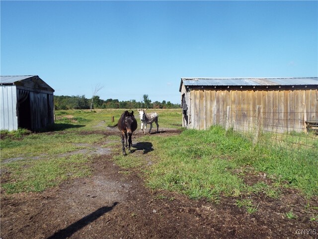 view of yard with an outdoor structure and a rural view