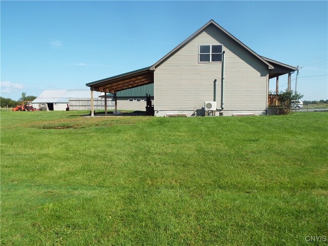 view of side of property with a lawn and a carport