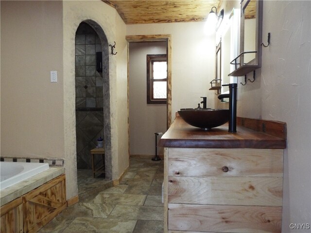 bathroom featuring vanity, wood ceiling, and a washtub