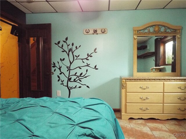 bedroom featuring a paneled ceiling and light tile patterned floors