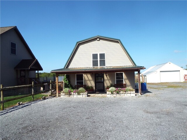 view of front facade featuring an outbuilding, a garage, and covered porch