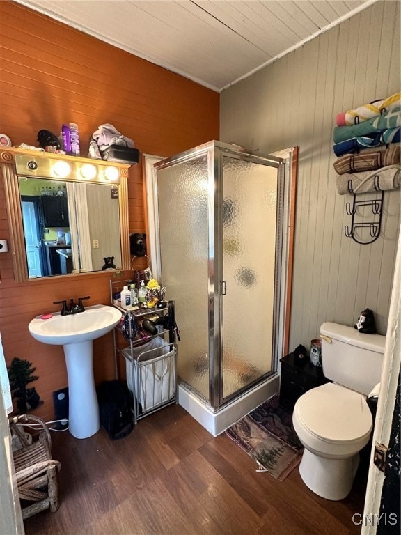 bathroom featuring wooden walls, walk in shower, and toilet