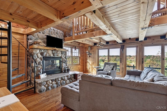 living room with beamed ceiling, wood ceiling, wood walls, hardwood / wood-style flooring, and a fireplace