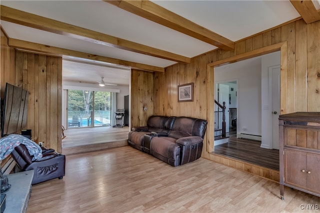 living room featuring light hardwood / wood-style flooring, wooden walls, and a baseboard radiator