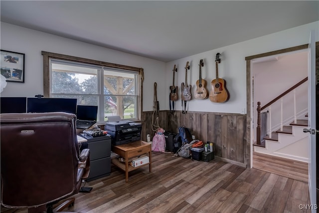 home office with wooden walls and hardwood / wood-style flooring