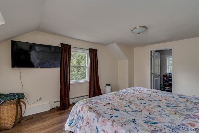 bedroom with vaulted ceiling, baseboard heating, and hardwood / wood-style flooring