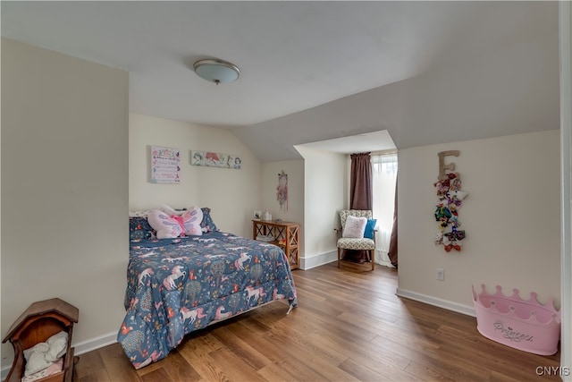 bedroom with hardwood / wood-style flooring and lofted ceiling