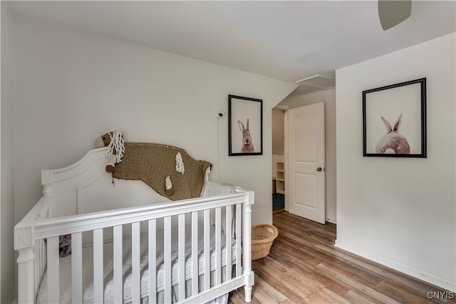 bedroom featuring a nursery area and hardwood / wood-style flooring